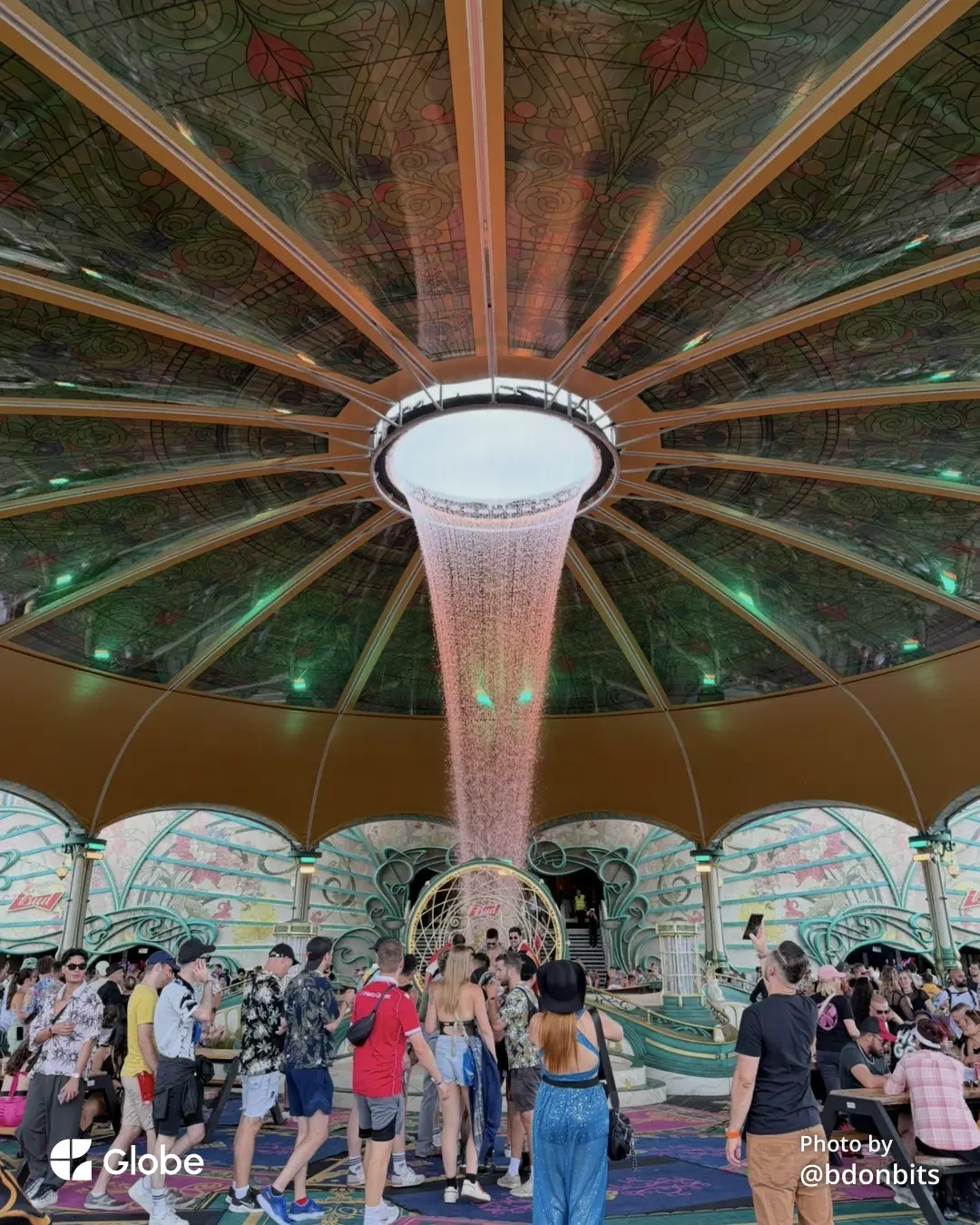 Tomorrowland's Freedom stage dome, with a golden light shower pouring from the ceiling over the daytime crowd