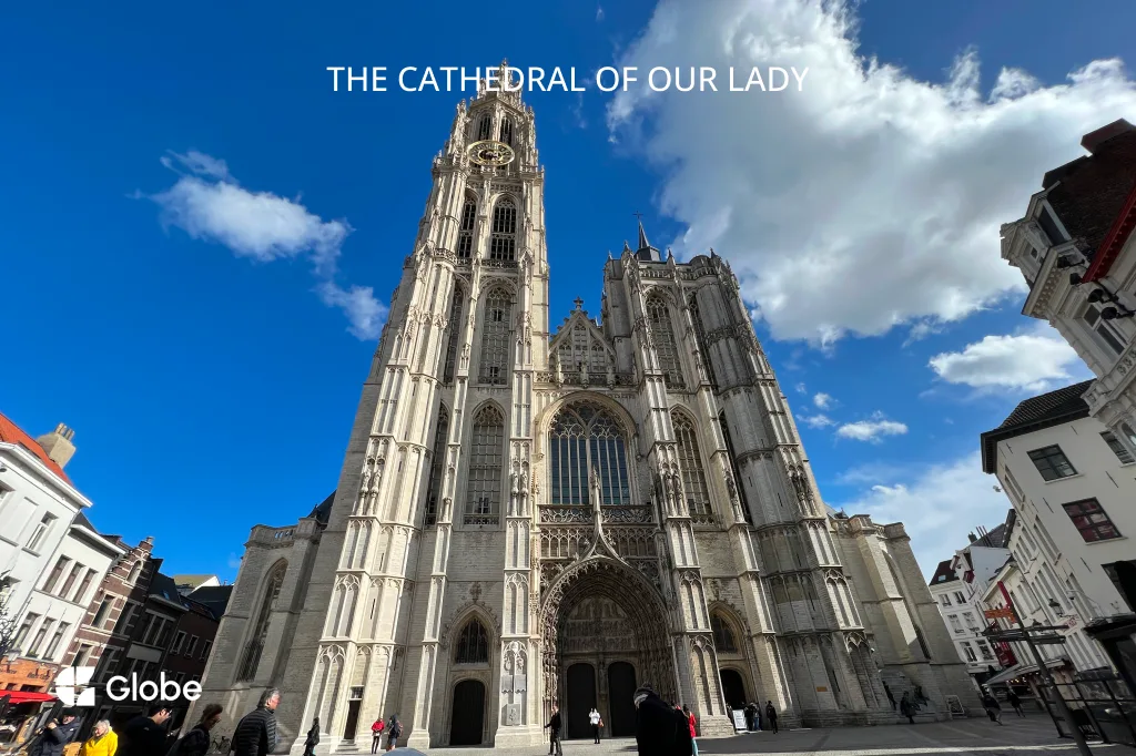Antwerp Cathedral of Our Lady seen from the front, its Gothic spire against a partly cloudy blue sky