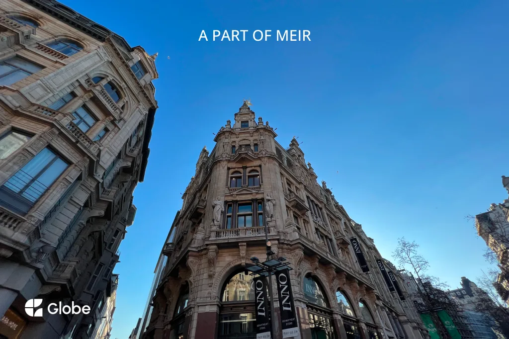 Ornate historic facade along Meir, Antwerp's main shopping street, seen from below against a clear sky